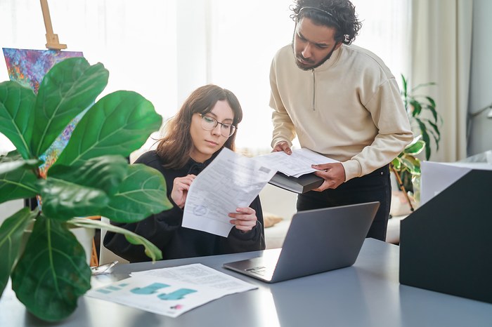 Des personnes examinent un avis de passage d'huissier