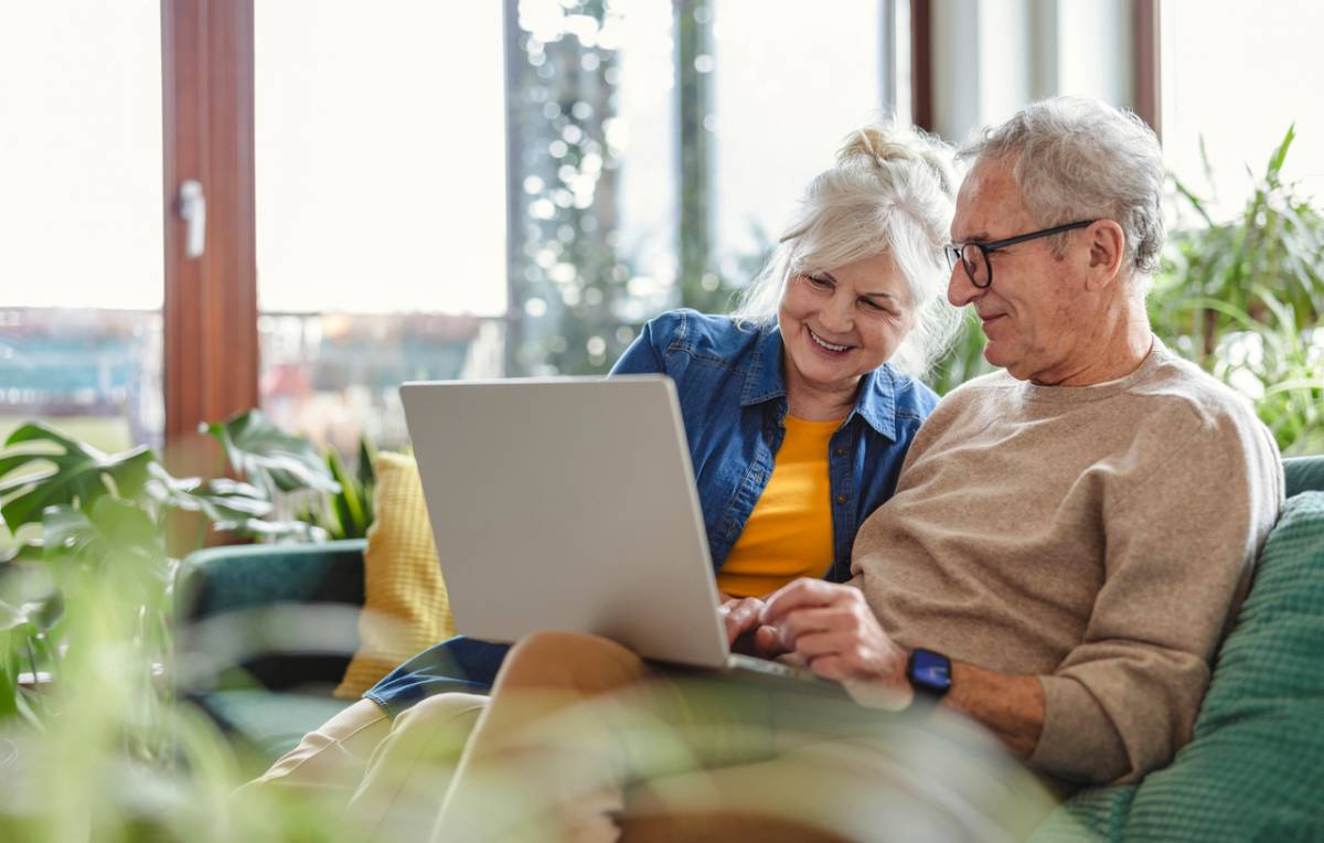 Couple de seniors comparant les offres de mutuelle santé sur un ordinateur portable